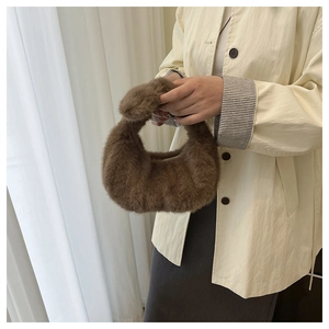 Borsa a mezzaluna in finta pelliccia marrone scuro portata con un cappotto beige