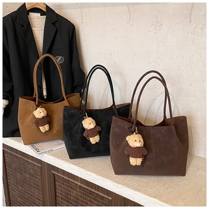 Détails de sacs cabas en daim marron et noir avec d'adorables pendentifs en ours