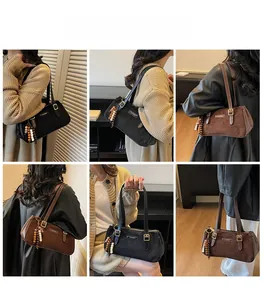 Dettaglio della borsa hobo in camoscio con nappa in legno e logo del marchio in metallo