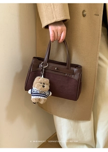 Dettaglio della borsa Kelly in pelle marrone scuro con inserti in pelle scamosciata