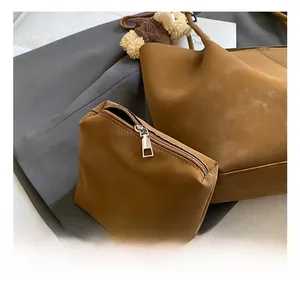 Détail du grand cabas en daim marron avec ferrures argentées et breloque ours en peluche