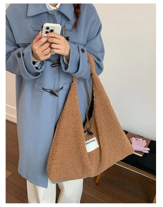 Detail of plush brown shearling shoulder bag with toggle button and SEEYOU label