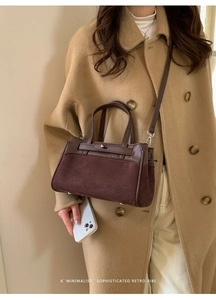 Primo piano di una borsa Kelly marrone scuro in pelle opaca e dettagli in pelle