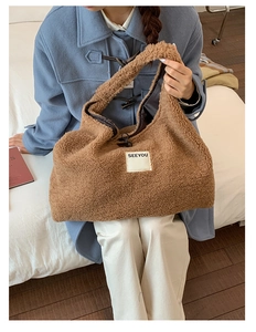 Detail of soft brown faux shearling tote bag with SEEYOU label on a stylish model