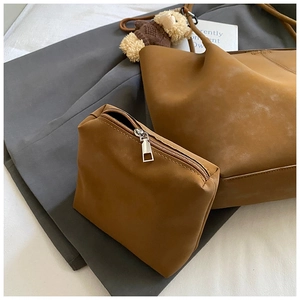 Detail of vintage brown suede tote bag with matching pouch and plush bear charm