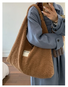 Detail of soft brown teddy faux fur tote bag with logo patch and textured plush finish
