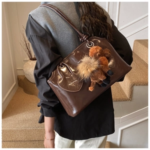 Dettagli della borsa tote in pelle marrone cerata con ciondolo a cuore e peluche soft