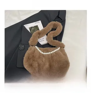 Détail d'un sac bandoulière en peluche marron avec une élégante chaîne en grosses perles