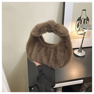 Dettaglio borsa a mano marrone in peluche con manico annodato e morbida trama invernale