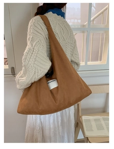 Close-up of caramel fleece tote bag with white SEEYOU label on a minimalist wide shoulder strap