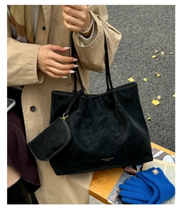 Détail du sac cabas en daim noir avec petite pochette zippée et logo doré