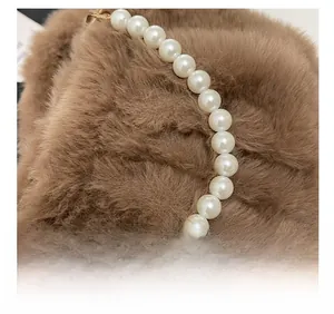 Détail de la poignée en perles élégante sur un sac à bandoulière en peluche marron