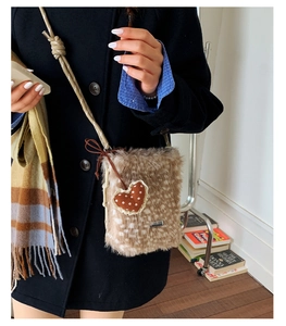 Detailaufnahme der Plüschtasche mit Hirschprint, Herzanhänger und Seilgurt