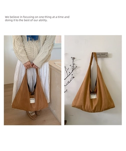 Detail of tan suede tote bag featuring a white logo patch and spacious shoulder strap