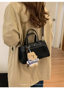 Dettaglio borsa a mano vintage nera in pelle mista con ciondolo a orsetto e tracolla