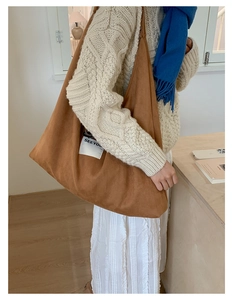Close-up of brown suede hobo tote bag featuring a white Seeyou fabric label decoration