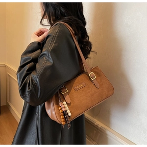 Sac baguette en daim marron avec breloque en perles de bois et logo métallique