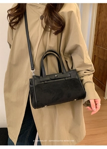 Dettaglio borsa Kelly retrò in pelle nera con texture a grana e inserti in pelle scamosciata
