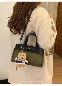 Dettaglio borsa Kelly in pelle scamosciata verde e pelle nera con ciondolo a orsetto