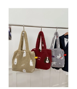 Dettaglio di borse tote in peluche con stampe di cani in kaki, rosso scuro e grigio