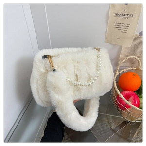 Détail du sac à main en fausse fourrure blanche avec chaîne en perles et poignée douce
