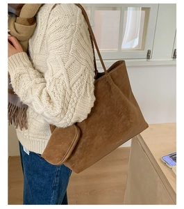 Retro brown leather tote bag with a small pouch shown on a cozy white knitted sweater
