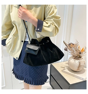 Detail of vintage matte black bucket bag with drawstring and hanging leather coin purse