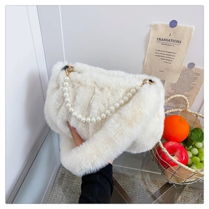 Vue détaillée du sac en peluche blanc avec poignée en perles et fausse fourrure douce