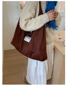 Brown faux suede tote bag with SEEYOU label shown on a model with a blue scarf