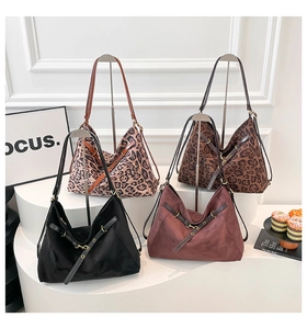 Detail view of large tote bags in leopard print, black, and burgundy on display stands