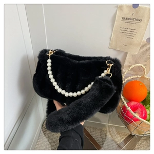 Détail du sac à main noir en fausse fourrure avec chaîne en perles et bandoulière pelucheuse