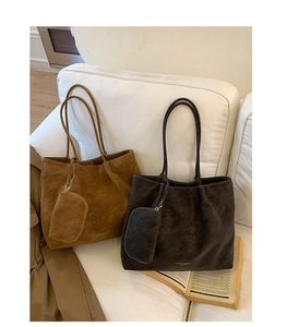 Détail du sac cabas en cuir mat vintage avec porte-monnaie assorti sur un canapé blanc