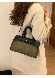Dettaglio di una borsa retrò minimalista in pelle scamosciata verde scuro e pelle