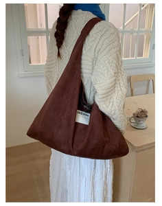 Detail of brown faux suede tote bag featuring a white SEEYOU woven label and soft texture