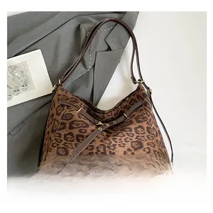 Detail of leopard print tote bag featuring brown leather straps and buckle decoration