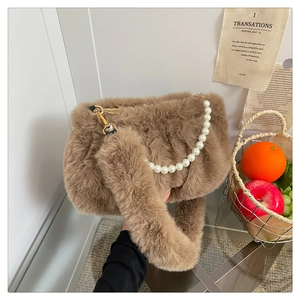 Vue détaillée du sac en peluche marron avec anse en perles et fermoir doré brillant