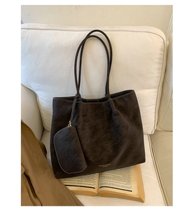 Macro detail of dark coffee vintage tote bag featuring gold embossed text on matte leather