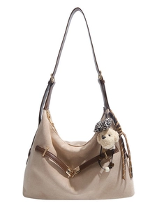 Minimalist cream dumpling shoulder bag with brown leather strap and puppy charm