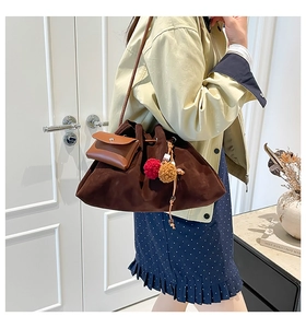 Detail of vintage brown suede hobo bag with ethnic tassel and mini coin purse