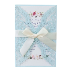 Light blue laser-cut wedding invitation with cream satin ribbon and floral insert