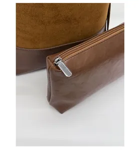 Detail of dark brown leather bucket bag with inner matching zipper pouch and silver hardware