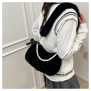 Détail du sac à main en fausse fourrure noire avec poignée en perles et bandoulière douce