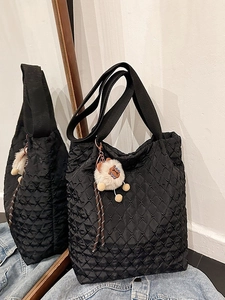 Black quilted tote bag with diamond pattern and plush sheep charm for daily commuting