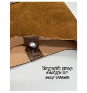 Detail of silver magnetic buckle closure on a brown suede vintage bucket bag