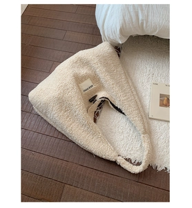 Detail shot of the plush cream-colored faux shearling texture and SEEYOU woven label