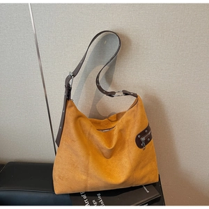Detail of ginger suede tote bag with brown adjustable strap and side decorative zipper