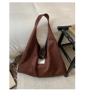 Detail of dark brown faux suede tote bag with white woven SEEYOU logo label