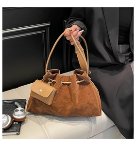 Detail of caramel suede bucket bag with pleated texture and matching mini pouch accessory