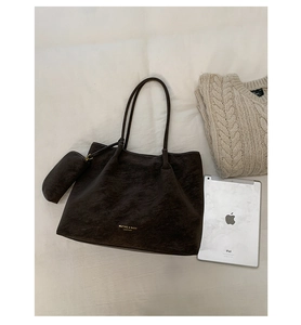 Détail du grand sac cabas en cuir marron foncé avec pochette interne et logo doré