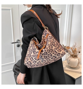Detailed view of the large leopard print tote bag with brown leather straps and buckle